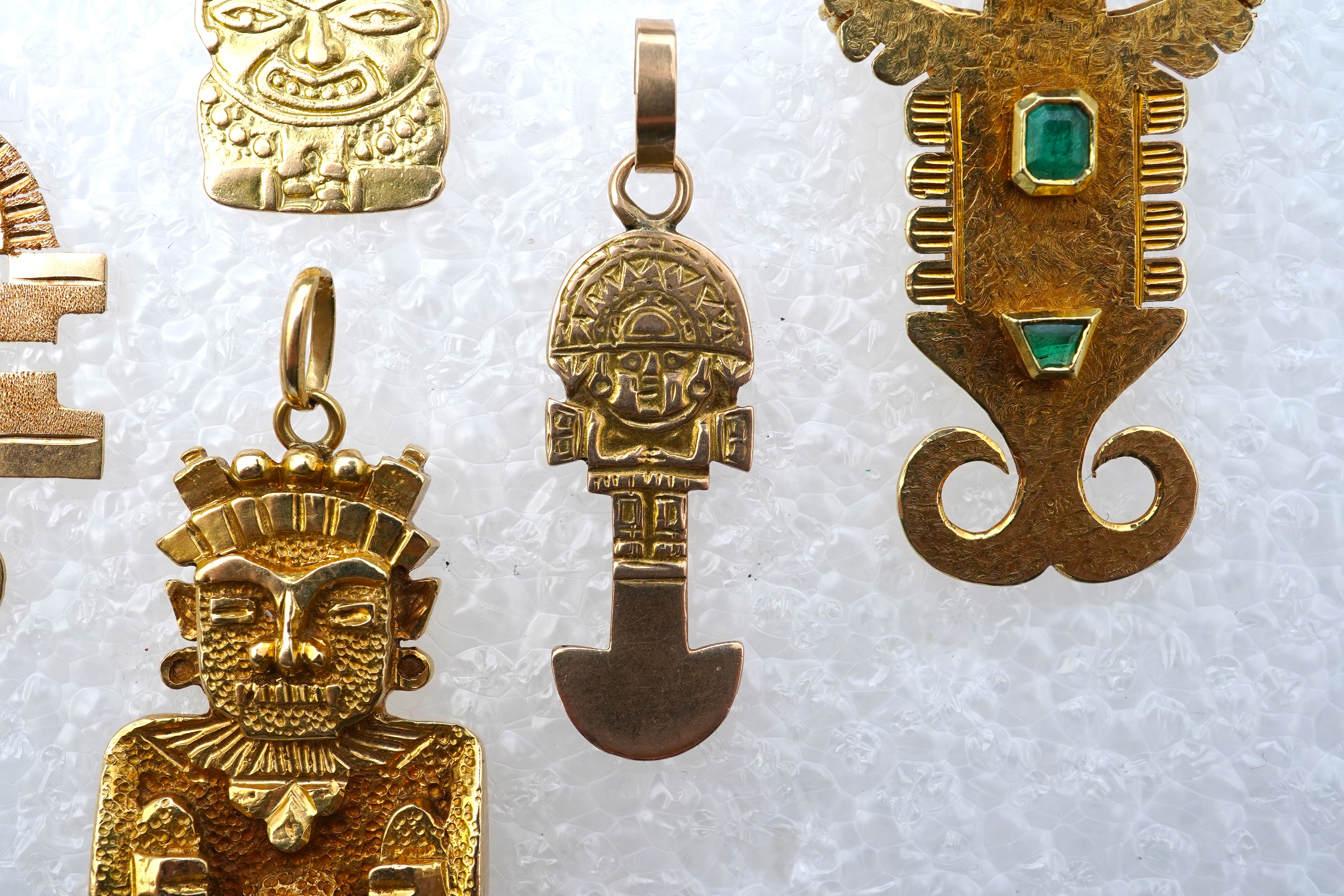 A collection of five gold pendants